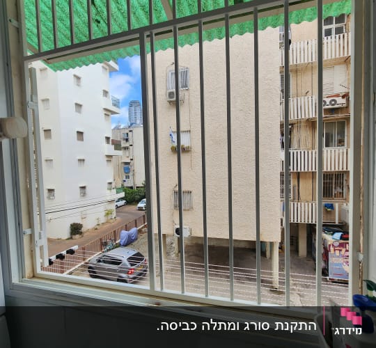 סורגים ישרים ממתכת בצבע לבן המותקנים בחלון דירה